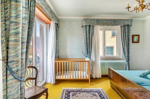 a baby bedroom with a crib and a window at Gîte du forgeron - 6 à 8 personnes - Centre Alsace - Saint-Hippolyte in Saint-Hippolyte