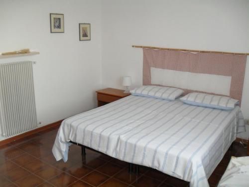 a bedroom with a white bed with blue pillows at Casa Vacanze San Zeno di Montagna in San Zeno di Montagna