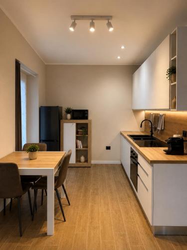 a kitchen with a table and a dining room at La Terrazza, comfort e relax tra i laghi in Borgomanero