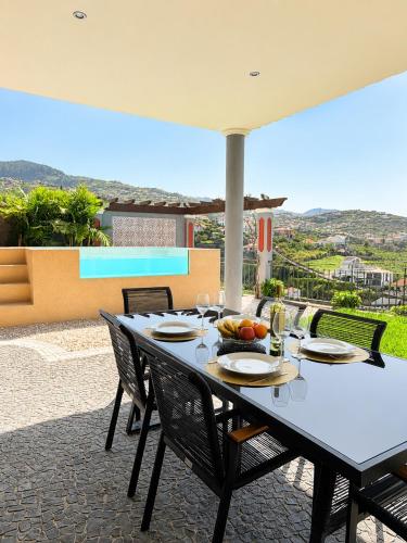 a table with chairs and food on a patio at Casa do Piquinho in Ponta do Sol