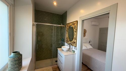 a bathroom with a shower with a sink and a mirror at Villa Delicia in Torrox