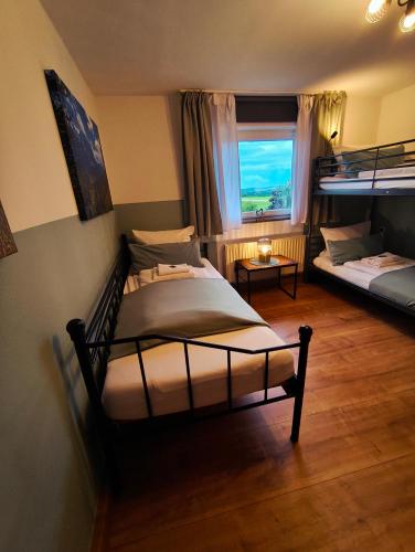 a bedroom with two beds and a window at Ferienwohnung Berge & Seen in Hohenpeißenberg