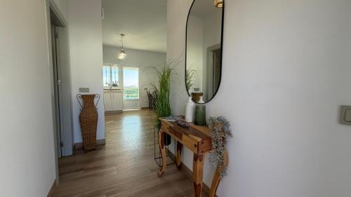 a hallway with a mirror and a table and vases at Villa Delicia in Torrox