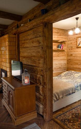 a bedroom with a bed in a log cabin at Podlaska Chatka Dziadka in Ciwoniuki