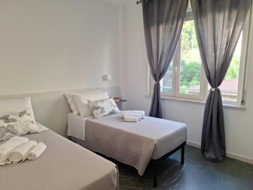 two beds in a room with a window at Vanity Suite in Cefalù