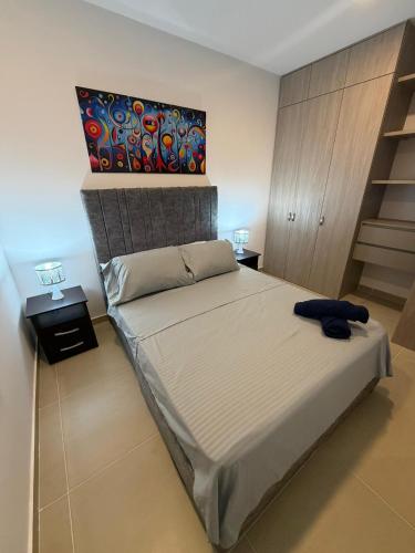 a bedroom with a bed and a painting on the wall at Espectacular alojamiento in Gaira