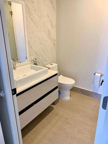 a bathroom with a white sink and a toilet at Ocean View Condo in Mazatlán