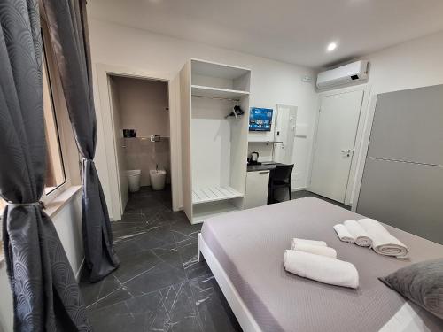 a bedroom with a bed with towels on it at Vanity Suite in Cefalù