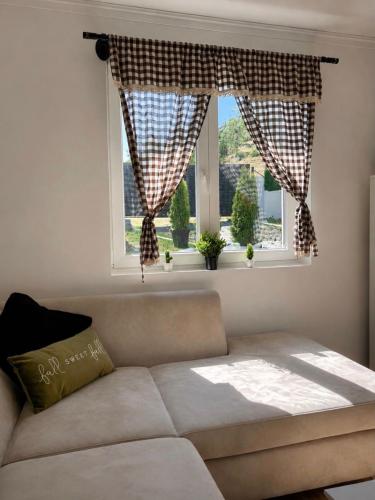 a living room with a couch and a window at De Papel Villa in Jankoviči