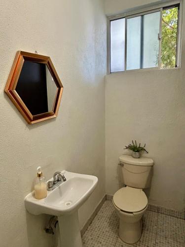a bathroom with a toilet and a sink and a mirror at Estudio #1 a 10 min del malecon in La Paz