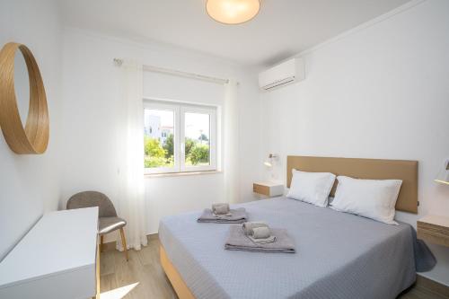 a bedroom with a bed with two towels on it at Renovated Algarve Apartments with Pool in Armação de Pêra