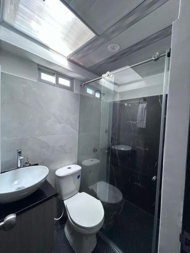 a bathroom with a toilet and a sink and a shower at Park Suite in Ibagué