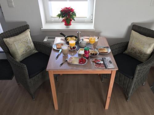 a table with food and drinks on it with two chairs at Karwendel Apartments in Scharnitz