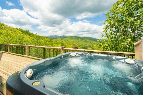 a jacuzzi tub on the deck of a house at Cucumber Tree Lodge in Banner Elk