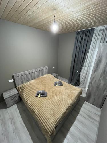 a bedroom with a bed with two shoes on it at Leo Guesthouse in Dolasvip'i