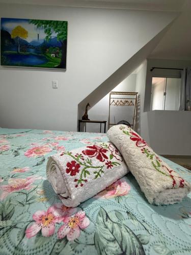 a bedroom with a bed with a flowered blanket at Studio 25 Na Cidade do CAFÉ 300m do Centro in Brejetuba