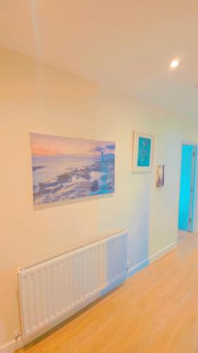 a room with a white wall with paintings on it at studio with ensuite in New Bedfont