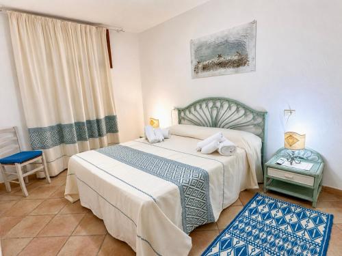 a bedroom with a bed and a chair and a window at GioYa House in Pittulongu
