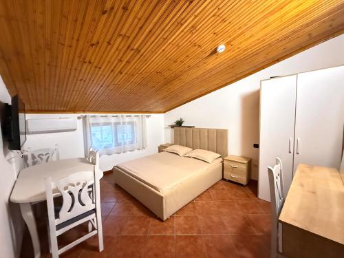 a bedroom with a bed and a wooden ceiling at Hotel Laura in Velipojë