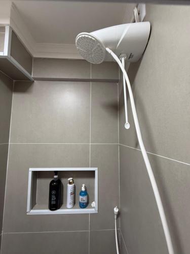 a shower with a shower head in a bathroom at Studio 25 Na Cidade do CAFÉ 300m do Centro in Brejetuba