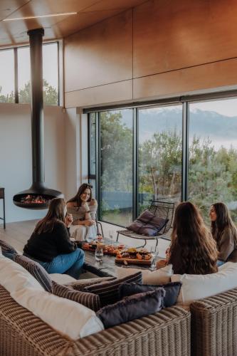 a group of women sitting on a couch in a room with windows at On The Edge, Luxury - KK43111 in Kaikoura