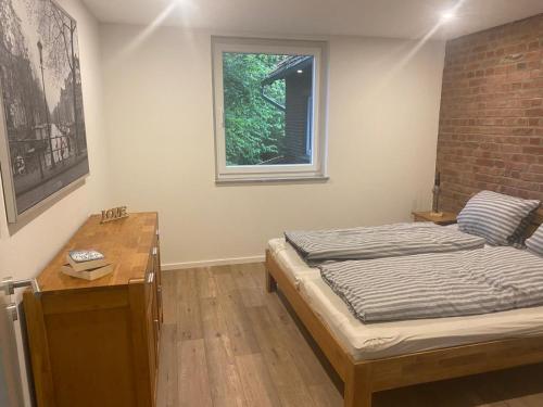 ein Zimmer mit einem Bett, einem Schreibtisch und einem Fenster in der Unterkunft Hof Husmann in Extertal
