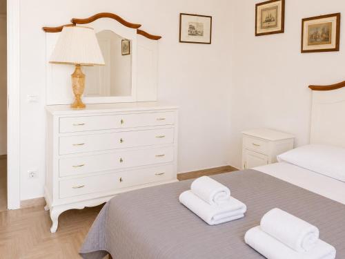 a bedroom with a white dresser and two towels on a bed at Malù camera doppia in Appartamento - lungomare Crotone in Crotone