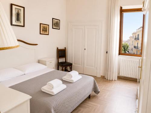 a white bedroom with two towels on a bed at Malù camera doppia in Appartamento - lungomare Crotone in Crotone