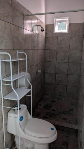 a bathroom with a white toilet and a shower at WinMen in El Sunzal