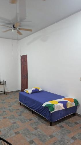 a bed in a room with a ceiling fan at WinMen in El Sunzal