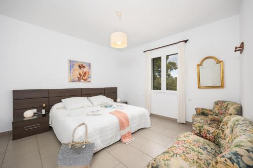 a bedroom with a bed and a chair at Villa Luisa in Cala Galdana