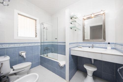 a blue and white bathroom with a toilet and a sink at Villa Luisa in Cala Galdana