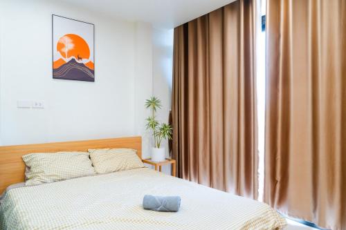 a bedroom with a bed and a large window at Nest West Lake - Apartment Hà Nội in Hanoi