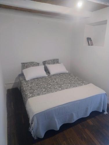 a bed with two pillows on it in a room at Chez Eli in Luri