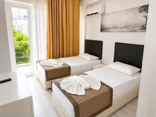 a hotel room with two beds and a window at Giray Hotel in Alanya