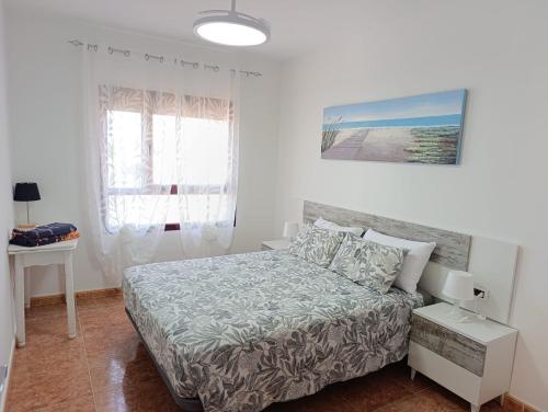 a small bedroom with a bed and a desk at Bahia Sol Dream -Caleta de Fuste- in Caleta De Fuste