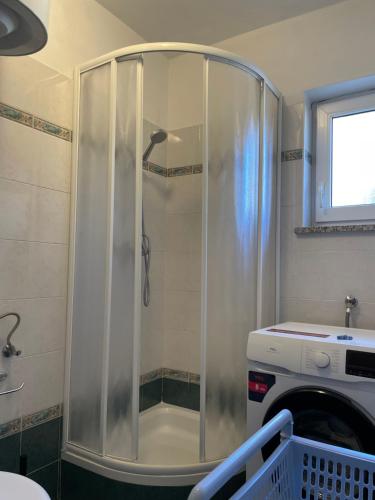 a shower with a glass door in a bathroom at Apartments Marija in Cres