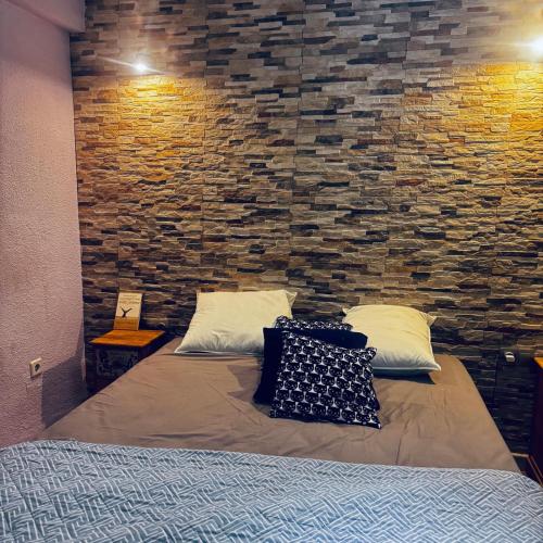 a bed in a room with a stone wall at Veleta Montserrat - Alicante in Alicante