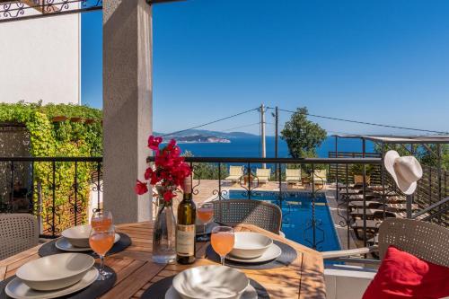 a table with plates and wine glasses on a balcony at Apartments Oktopus in Sutomore