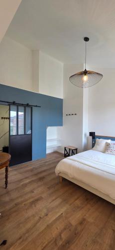 a bedroom with a bed and a pendant light at Chez Mary in Larzicourt