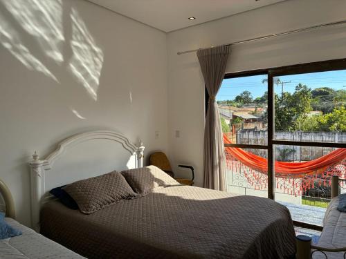 a bedroom with a bed and a large window at Casa Guimarães II in Chapada dos Guimarães
