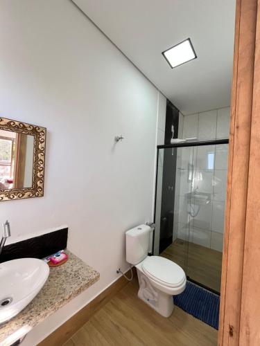 a bathroom with a toilet and a glass shower at Casa Guimarães II in Chapada dos Guimarães