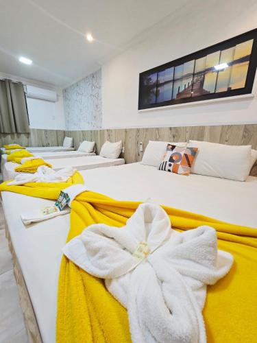 a row of white beds with towels on them at Pousada Gente Bonita Mirante in Búzios