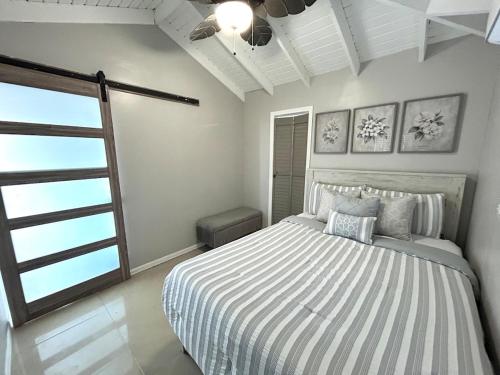 a white bedroom with a bed and a window at Couples Retreat in Nazareth