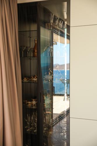 a room with a glass display cabinet with vases at DAED Luxury Residence in Sarandë