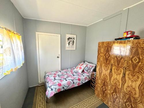 a small bedroom with a bed and a window at River Cottage on Cherry - Pet Friendly in Evans Head