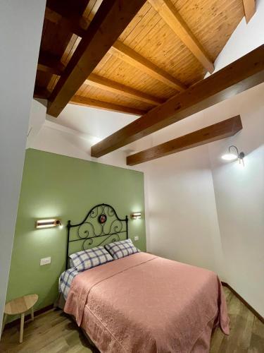 a bedroom with a bed in a green wall at Casa Iris in Omegna