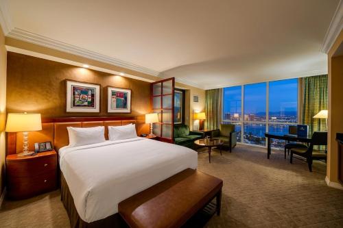a hotel room with a large bed and a desk at MGM Signature No Resort Fees, Jacuzzi & Pools in Las Vegas