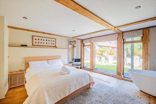 a bedroom with a bed and a bath tub at Airy Barn Conversion Private Parking & Garden in Burrington