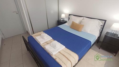 a bed with towels on it in a bedroom at Apartamento acolhedor com AC no centro de Angra in Angra do Heroísmo